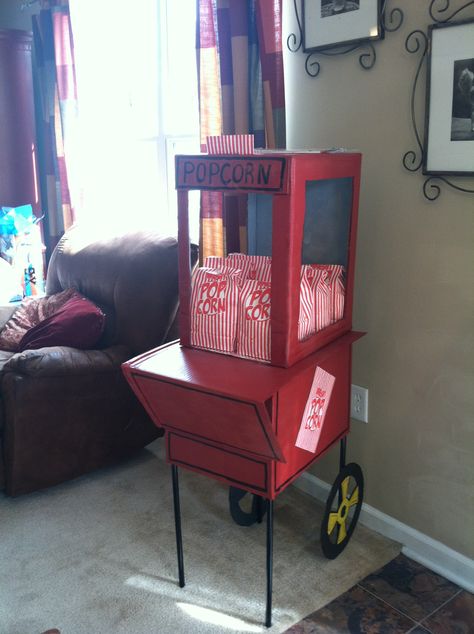 Popcorn stand made out of cardboard Diy Popcorn Machine, Diy Popcorn Machine Cardboard, Diy Popcorn Cart, Diy Popcorn Stand, Rockabilly Party, Popcorn Cart, Popcorn Stand, Backyard Movie Party, Diy Popcorn