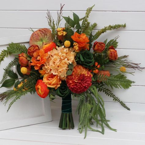 Rich tones of burnt orange, deep crimson, and golden yellow bring a burst of fall magic to your special day. This handcrafted bouquet is inspired by the warm glow of autumn, perfect for those looking to add a rustic, vibrant touch to their wedding or celebration. 🌻✨ #orangewedding #burntorangewedding #forestwedding #forestgreenwedding #fallwedding #fauxflowerarrangement #weddingflorist #weddingvendor Orange And Green Bouquet, Forest Green Wedding, Faux Bouquet, Green Bouquet, Bridesmaid Bouquets, Faux Flower Arrangements, Parts Of A Flower, Wedding Flowers Summer, Flowers Summer