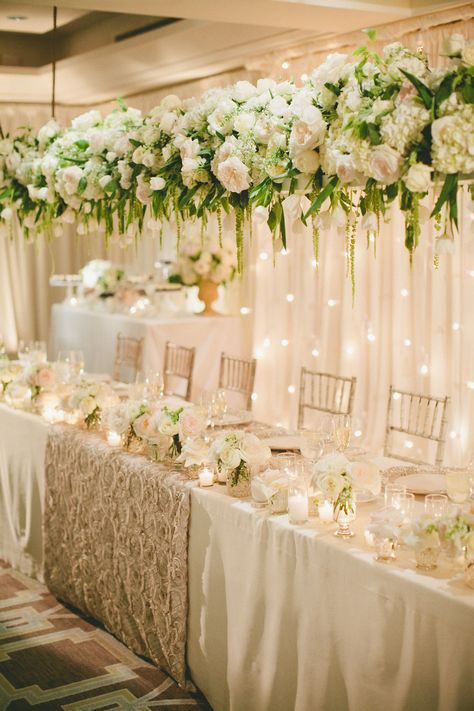 A longer view of the panel table. Gorgeous floral arrangement hanging above. Tablecloth Photography, Dreamy Tablescapes, Table Wedding Decorations, Head Table Wedding Decorations, Floral Designs Arrangements, Head Table Decor, Table Flower Arrangements, Head Table Wedding, Floral Installation