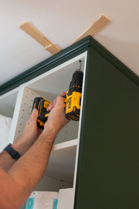 Adding crown molding to the ceiling. Come learn our tips for installing IKEA kitchen cabinets and making them look high-end and built-in. We used these dark green cabinets in our laundry room and they turned out absolutely gorgeous! #IKEA #ikeakitchen #DIYkitchencabinets Crown Molding On Ikea Kitchen Cabinets, Ikea Kitchen Cabinet Hacks Built Ins, Wall Kitchen Cabinets Ideas, Upper Cabinet Molding, Installing Ikea Kitchen Cabinets, Ikea Kitchen Crown Molding, Ikea Sektion Axstad Kitchen, Ikea Crown Molding, Ikea Hacks Kitchen Cabinets