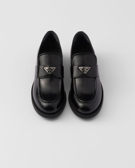 Upper with leather band Enameled metal triangle logo Monoblock rubber sole with hot-stamped logo Heel height 25 mm Prada Loafers Aesthetic, Loafers Aesthetic, Re Edition Prada, Prada Loafers, Leather Loafers Women, Loafers Women, Womens Black Flats, Luggage Bags Travel, Messenger Bag Backpack