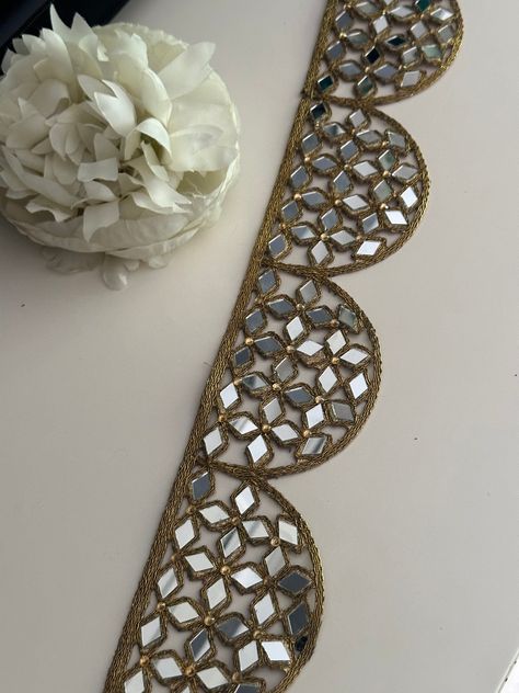 This Indian mirror embellished border beautifully crafted Indian mirror belt is very pretty for kaftans, mirror belts, embellished necks, saree trims, lehngas, sari borders, dupatta trims. Let your creativity flow and enhance your outfit :    Experience the magic of our geometric mirror  Trim, a true game-changer when it comes to adding a touch of glamour to your outfits. Picture shining mirror work in dazzling gold, masterfully crafted in a cutwork design, elevating your style to the next level. Whether you're revamping your favorite dress, enhancing a craft project, or adding flair to a variety of items, this trim instantly elevates your fashion game. Perfect for: - Sarees - Blouse designs - Dupatta trims - Gifting - Kaftans - Potli bags - Cushion covers - Upholstery Explore our extensiv Border For Mirror, Indian Mirror Work, Mirror Work Border, Mirror Belt, Indian Mirror, Sarees Blouse, Geometric Mirror, Mirror Trim, Potli Bags