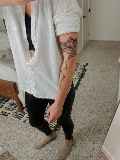 Woman’s minimal geometric mountain and lake tattoo in black ink. Back Tattoo Women Mountain, Water Tattoo Sleeve Women, River Arm Tattoo, River Inspired Tattoos, Cascading Tattoos, Waterfall Tattoo Minimalist, Upper Calf Tattoo Women, River Topography Tattoo, River Map Tattoo