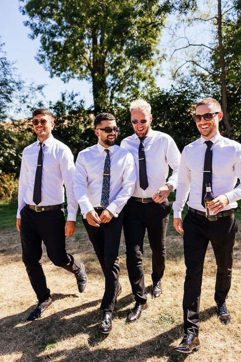 Groom walks with his groomsmen wearing white shirts and black ties with sunglasses Groomsmen Just Shirt And Tie, Groomsmen Shirt And Tie Only, Groomsmen White Shirts, Groomsmen Black Pants White Shirt, White Dress Shirt Black Pants, Black Pants Groomsmen, Casual Groomsmen Attire Outdoor Weddings, Groomsman Attire Black, Groomsmen Attire Black And White