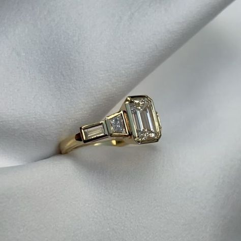 Lisa - Goldsmith Gemmologist on Instagram: "Just finished this lovely diamond engagement ring 💍✨   The centre stone is a 1.5ct emerald-cut diamond with trapezoid and baguette shaped diamonds either side. The ring is made in 18ct yellow gold and all diamonds are bezel set.   Bezel settings are becoming a popular choice for modern engagement rings ⭐️   If you’d like to try this ring on, book an appointment to visit the studio at www.settogether.com.au 😊   *This ring will be available in online shop soon 💕  #engagementring #sunshinecoastjeweller #ringmaker #jewellerydesigner #diamondengagementring" Wedding Band Stack Emerald Cut, Art Deco Bezel Engagement Ring, Trilogy Engagement Ring, Emerald Cut Ring, Stacked Wedding Bands, Bezel Engagement Ring, Modern Engagement Rings, Ring Ideas, Emerald Cut Diamonds