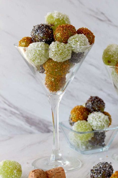 Close up view of a Martini glass filled with sugared grapes in gold, white and silver next to a small square glass bowl filled also with candied grapes Spiked Grapes, Appetizers In Martini Glasses, Martini Party Ideas Food, Martini Glass Appetizers, Nye Appetizers, Candied Grapes, Martini Party, Sugared Grapes, Gold Candy