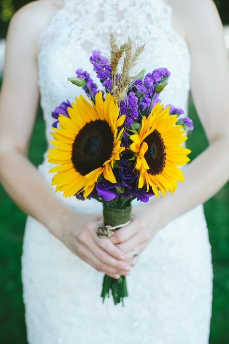 Remembrance Wedding Bouquet made by the Bride to honor the deceased: sunflowers to represent her dad and sister; 6 wheat heads for her 4 grandparents and 2 of the groom's grandparents, along with the wedding rings of her dad and two grandmothers. Purple lisianthus and statice for friends and family both near and far as the "cloud of witnesses" (Hebrews 12:1), with a few buds for those yet to come. Purple Bouquet With Sunflowers, Sunflower Wedding With Purple, Sunflower And Purple Wedding Bouquet, Sunflower Purple Wedding, Sunflower And Purple Wedding, Sunflower And Lavender Wedding, Purple And Sunflower Wedding, Purple Sunflower Wedding, Remembrance Wedding