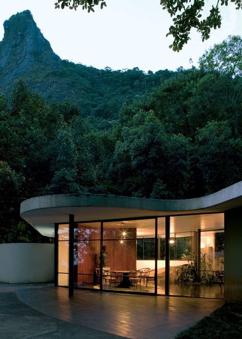 a low, curving facade house with glass walls under a tall mountain Oscar Niemeyer Architecture, A Modern House, Mid Century Architecture, Oscar Niemeyer, Organic Architecture, Architecture Exterior, Le Corbusier, Beautiful Buildings, Interior Architecture Design