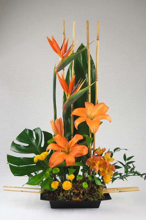 Spiky, brilliantly colorful birds of paradise are a dramatic and long-lasting addition to any flower arrangement. With their beak-like appearance, these unique "blooms" look like winged creatures poised for flight! Matched with fresh flowers and exotic leaves. - Hand delivered in a square black container. Hawaiian Flower Arrangements, Rustic Flower Arrangements, Arreglos Ikebana, Floral Art Arrangements, Tropical Floral Arrangements, Tropical Flower Arrangements, Winged Creatures, Sunflower Arrangements, Altar Flowers