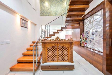 A beautiful concept of design and use of space. Carved temple by the staircase.   Urbanclap Interior Designer: @studioignitus   #homes #interiors #interiordesign #homeinteriors #interiordesigner #wooden #staircase #carvedtemple #woodentemple #beautiful #interiorsforall #urbanclap #uchomes #ucprofessionals Wooden Temple Design, Wooden Pooja Mandir Designs, Wall Mandir, Under Stairs Design, Pooja Mandir Designs, Pooja Room Designs, Mandir Designs, Room Under Stairs, Small Room Interior