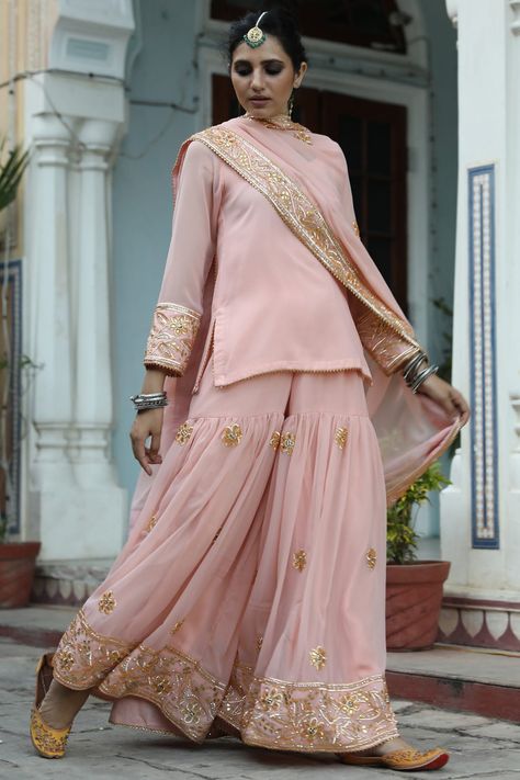 Featuring a peach kurta in georgette and shantoon base with gota embroidery. It is paired with matching sharara pants and a dupatta.  FIT: Fitted at bust and waist. COMPOSITION: Georgette, Shantoon. CARE: Dry clean only. Peach Sharara Suit, Sharara Suit Designs Latest, Peach Sharara, Gulabo Jaipur, Sharara Suit Designs, Georgette Kurta, Sharara Pants, Mehendi Outfits, Border Fabric