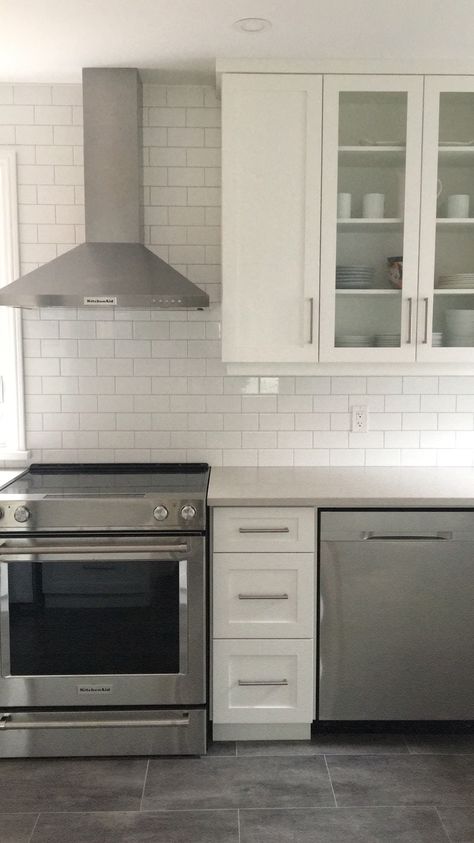 White kitchen featuring white shaker cabinets, caesarstone london grey quartz countertops, echo floor london grey flooring, white subway tile from Rona, kitchenaid appliances White Kitchen Cabinets Gray Floor, White Cabinets Grey Countertops, Light Grey Quartz Countertops, Caesarstone London Grey, Light Grey Countertops, Grey Quartz Countertops, Walnut Interior, Kitchenaid Appliances, Kitchen Cabinets Grey And White