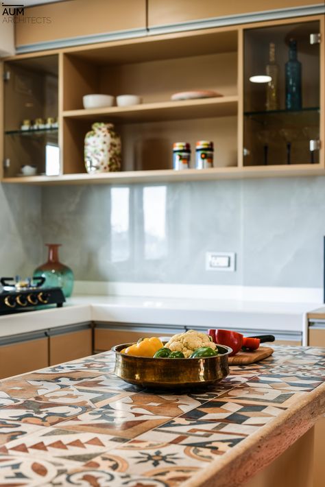 Hand made tiles, a warm color palette infuse a sense of Indian aesthetics to this modern kitchen.  #teamaum #aumarchitects #kitchenideas #kitchendesign #decor #homestyling Indian Kitchen Countertops, Indian Kitchen Tiles, Indian Kitchen Aesthetic, Kitchen Dado Tiles Design, Kitchen Tiles Wall Indian, Indian Modern Kitchen, Kitchen Dado Tiles, Indian Kitchen Interior Traditional, Dado Tiles