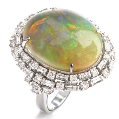 For Sale on 1stdibs - This eye catching cocktail ring boasts of color with a large oval shaped fiery Opal offering bursts of red, green and blue. With the Opal measuring appx. Luxury Cabochon Opal Ring For Engagement, Luxury Multi-stone Dome Ring For Engagement, Sapphire Cocktail Ring, Opal Band, Yellow Gold Wedding Band, Jewelry Appraisal, Double Halo, Diamond Cocktail Rings, Domed Ring