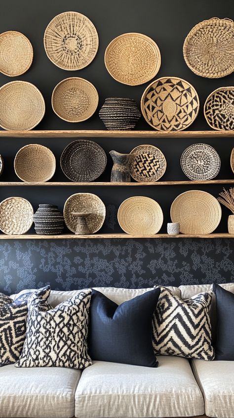 African wall art display with woven baskets on wooden shelves above a sofa, accented by grey and navy decorative pillows. Above The Couch Decor, Couch Decor Ideas, Cozy Setup, Above The Couch, African Baskets Wall, Earthy Living Room, African Inspired Decor, Patterned Wallpaper, Wall Art Display