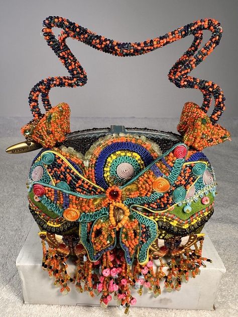 This vintage Mary Frances purse is a rare find, featuring a colorful and beautifully beaded jeweled butterfly. The satchel/top handle style is perfect for everyday use and the snap closure ensures your belongings stay secure. The multicolor exterior is made of a cotton blend with beaded accents, while the black lining is made of fabric. This purse is a unique addition to any collection, with a fun and playful butterfly theme. The small size and beaded handle/strap make it easy to carry and add a touch of vintage charm to any outfit. Made in France, this Mary Frances purse is a must-have for any fashion-forward woman. Mary Frances Purses, Butterfly Purse, Mary Frances Bags, Mary Frances, Butterfly Theme, Bead Embroidery, Beaded Embroidery, Vintage Charms, Purses And Handbags