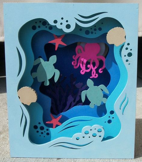 Wood box with various tones of blue on each panel depicts under the sea scene of beige scallop shells, blue tone waves, salmon-colored starfish, sea green sea turtles, pink octopus, and deep purple coral.  Second photo shows close-up of floor of wood box.  The floor is painted in blue with a sea glass effect of glitter pieces. Easy Kids Art Projects, Paper Cutout Art, 3d Paper Art, Murals For Kids, Paper Artwork, Paper Cut Art, Paper Cutout, Paper Quilling, A Sea