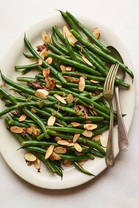 This recipe for green beans almondine combines tender crisp green beans with caramelized shallots, sliced almonds and fresh parsley. It’s a delicious side dish simple enough for a weeknight dinner, but fancy enough for a holiday meal! Green Beans With Shallots, Thanksgiving Green Beans, Delicious Dinner Ideas, Green Beans With Almonds, Green Beans Almondine, Easy Green Beans, Caramelized Shallots, Lemon Green Beans, Sauteed Green Beans