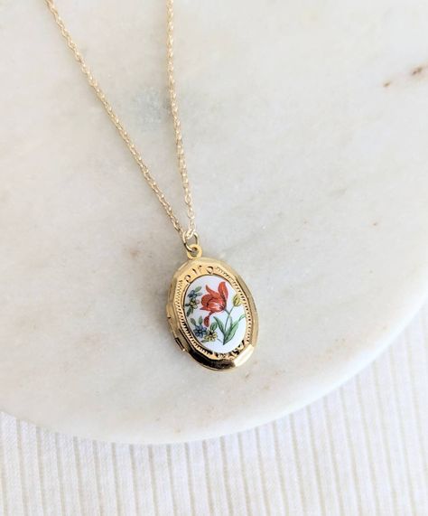 This small and dainty little gold plated locket features a sweet red-orange tulip flower vintage glass cabochon. It opens with the hinge at the side and there is space inside for a photo, secret message or little hand stamped initial. Suspended from either a gold plated chain with lobster clasp or a 14k gold filled chain with spring clasp close. Personalise for the perfect gift with a little hand stamped tag (fits one single Initial) https://etsy.me/33z0KEa or a Crystal birthstone: https://etsy.me/2HxFczT Add a Hand Stamped Initial Inside (pic 5) https://etsy.me/3BPkx0b Handmade with LOVE in Australia 🐨 | ADDITIONAL INFORMATION | Gold filled jewellery is an affordable alternative to solid gold that is durable, tarnish resistant and wearable for people with sensitive skin. Please allow 1-4 Vintage Floral Ring, Dainty Vintage Jewelry, Cute Etsy Finds, Gold Stacked Necklaces, Thrifted Jewelry, Vintage Gold Jewellery, Vintage Locket Necklace, Locket Vintage, Dainty Jewellery