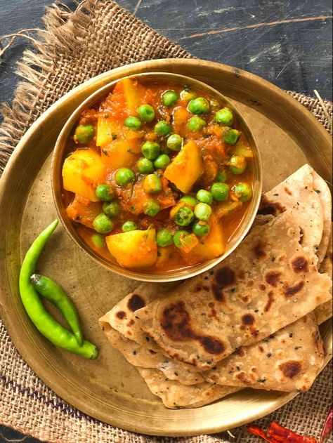 Aloo Matar Sabzi Recipe is a very traditional Punjabi dish that is made with potatoes and peas, simmered in light and tangy tomato gravy. The recipe has a delicate addition of spices , it is simmered to perfection brings out the essence of this flavorful dish. Serve the Aloo Mutter Sabzi along with steamed rice, parathas, phulka's or naan's for a perfect weeknight dinner. Have a look at what other recipes can be made with aloo: Mughlai Aloo Matar Gobi Recipe Chole Aloo Mughlai Aloo, Indian Peas, Aloo Mutter Recipe, Aloo Mutter, Tomato Gravy Recipe, Gobi Recipe, Potatoes And Peas, Aloo Recipes, Tomato Gravy