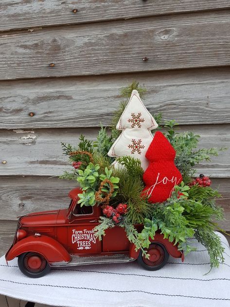 Red Trucks have become a classic Christmas decoration it can easily be displayed on a table top, fireplace mantel or hearth.

This red truck is made of metal and rustic in appearance. Decorated with a variety of greenery, red berries, a fabric creamy white Christmas tree and a red dree with the word Joy on the front. I have added "Farm Fresh Christmas Trees" to both door. Farm Christmas Decor, Metal Truck Decor, Table Top Fireplace, Truck Christmas Decor, Door Measurements, Red Truck Christmas, Word Joy, Classic Christmas Decorations, Christmas Red Truck