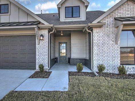 Drake Designer Elevation. Entry Door: NEW 4-lite 106 entry Front Door Color: Homburg Gray SW 7622, Garage Door Color: Iron Ore SW 7069, Siding Paint Color: Dorian Gray SW 7017, Black Windows on Front Elevation, Black Metal Roof Accents. Gray Garage Door Brick House, Tan House Black Accents Exterior, Grey Brick Black Windows, Sw Homburg Gray Exterior Paint, Iron Ore Garage Door, Gray Garage Door, Homburg Gray, Roof Accents, Grey Garage Doors