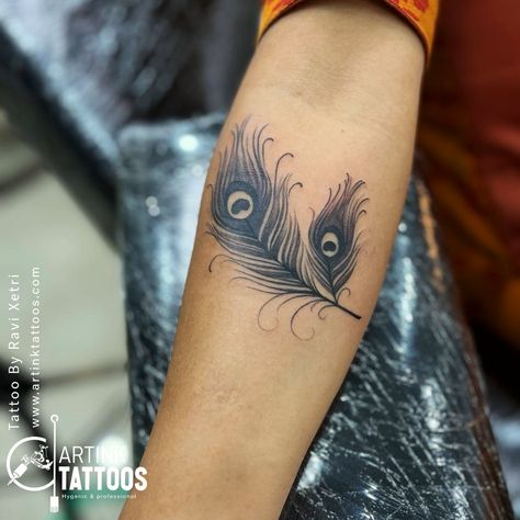 come visit us for your favourite tattoo at sentrum mall 2nd floor. Artink Tattoos by Ravi Xetri  Peacock Feather :-Peacock tattoos are associated with a number of different meanings and symbolism. In some cultures, the peacock tattoo is seen as a symbol of good luck, while in others it is seen as a symbol of wealth and prosperity. The peacock tattoo is also often seen as a symbol of beauty, grace, and elegance. #peacock #feather #forearm #tattoos #tattooink #asansol #west #bengal #ndia Peacock Feather Tattoo Black And White, Feather Tattoo Black, Peacock Tattoos, Feather Peacock, Tattoo Black And White, Peacock Feather Tattoo, Peacock Tattoo, Tattoo On Hand, Symbol Of Wealth