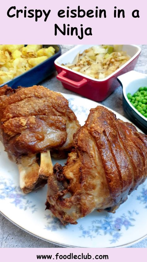 Two crispy eisbein on a serving platter next to side dishes of vegetables. Eisbein Recipe, German Fried Potatoes, Chicken And Ham Pie, Beef Schnitzel, Ham Hock Soup, Sauteed Potatoes, Pork Hock, Pea And Ham Soup, Multi Cooker