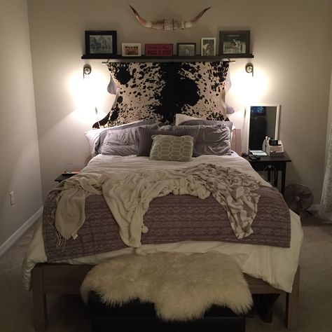 Updated snap of my bedroom. I found my dream cowhide at the local rodeo to hang on my wall. It was the perfect touch to finish my southern love inspired bedroom. That cowhide is dreamy! Cowhide On Wall Ideas Bedroom, Cowhide Rug On Wall Ideas, How To Hang A Cowhide On The Wall, Western Above Bed Decor, Cowhide Behind Bed On Wall, Cowhide Above Bed, Cowhide Bed Frame, Cowhide On Wall, Hanging Cowhide On Wall