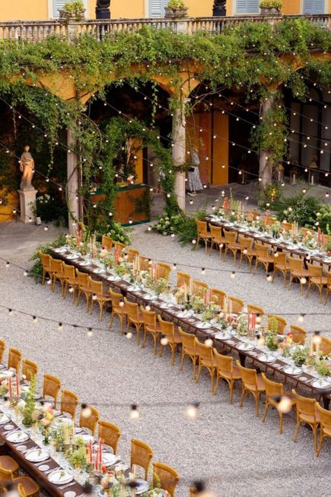 A stunning outdoor wedding reception at an Italian villa, featuring long tables with floral centerpieces and glowing string lights for a magical ambiance. romantic Italian villa wedding, wedding reception, outdoor wedding reception, Italian-inspired wedding decor, floral wedding centerpieces, elegant villa wedding, luxury Italian wedding, long table wedding setup, Mediterranean wedding theme, Italian garden wedding, breathtaking outdoor wedding, romantic wedding reception ideas, Spanish Style Wedding Table Decor, Italian Style Wedding Venues, Italian Villa Wedding Aesthetic, Mediterranean Wedding Theme, Villa Wedding Reception, Wedding Long Table, Floral Wedding Centerpieces, Italian Wedding Reception, Italian Garden Wedding