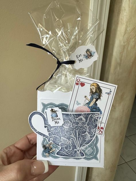 This set of 6 Fill My Teacup Navy Blue and Silver Alice in Wonderland tea party favors is perfect to fill with your own teabags! The trick is tipping your tea bag upside down, folding the bottom half of the teabag and stuffing the bottom half into the tea cup. Slightly shake the tea party favor to allow the loose tea to fill the bottom half of the teabag in the teacup. Voilà! Stuff the bag with sweets and treats! Whether it’s edible candy or cookies, everyone will follow the directions “Eat Me!” This box is approximately 3.5”x3.18”x2.25” and can store three to four medium cookies or many candies for your partygoers! Price does includes 6 favor boxes, 6 tags, 6 plastic bags and 6 ribbons. Ribbon may vary due to availability. The silver teacup is handstamped, and heat embossed for a raised t Alice In Wonderland Adult Party, Dit Gifts, Wonderland Party Theme, Tea Party Favor, Edible Candy, Alice In Wonderland Crafts, Alice In Wonderland Birthday Party, Bridal Party Invitations, Wonderland Events