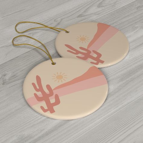 These custom made Christmas ornaments are minimalist style in earthy browns and pinks. There are four designs to choose from, or receive a discount if you purchase the set of four.  They are made to order from ceramic, with high quality inks used to print the designs. This design features a cactus with landscape and sun in the background. The colors are beautiful dusky pinks and browns. Ceramic ornaments are beautiful on your Christmas tree, or they make amazing tags for Christmas gifts.  .: One sided print .: Hanging hole .: White ceramic Please note that every screen will show the colors slightly differently, please allow for this :) Please let me know if you have any questions, I am only too happy to help. Thank you for shopping! Desert Christmas Decor, Tags For Christmas Gifts, Desert Christmas, Pink Desert, Scandi Christmas, Unique Christmas Ornaments, Nordic Christmas, Boho Christmas, Dusky Pink