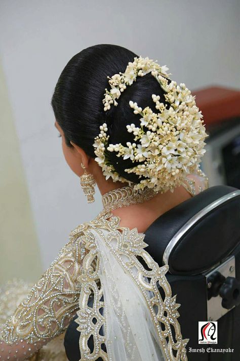 What a beautiful large low bun with real flower gajra! Care however should be taken before adopting such hairstyles, as due to it's high static charge, it will cause phlegm to move up in the throat, causing the voice to quaver & a frequent urge to clear the throat. A heavy chabi chhalla with a long & wide hook if inserted at the edge of the pleats of the saree, will reduce this problem as it's hook will activate the acupressure points that act to keep the throat clear. Bun With Gajra Hairstyles, Bun With Gajra, Floral Hairstyle, Flower Gajra, South Indian Wedding Hairstyles, Bun Style, Indian Bride Makeup, Wedding Bun Hairstyles, Bridal Bun