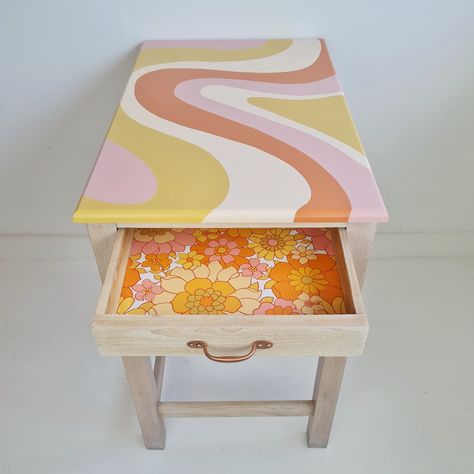 Painted desk with a flowing stripe desk design and an open drawer which has been lined with retro floral wallpaper. Cute Home Decor Paintings, Colorful Side Table Diy, Fun Painted Table, Funky Desk Ideas, Funky Painted Side Table, 70s Inspired Painted Furniture, Wallpaper A Table, Painted Stools Diy, Diy Table Paint