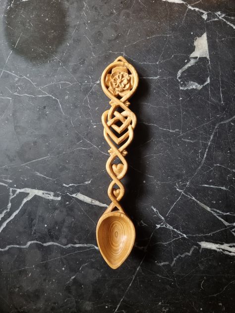 This love spoon measures appropriately 26 cm long by 4 cm wide. Love spoons were historically full of symbolism which I have tried to incorporate within a modern setting. I always include a hand written card explaining the symbolism of each design. This design has a stylised vine = growing closer, the rose = love blossoming, and celtic hearts = everlasting love. Love spoon making has a long tradition in Wales dating back to the early 1600's. The designs were driven by the passion of carvers who sought to produce works of art worthy of their beloved. Love spoons are now given as wedding gifts, anniversary's, birthdays, collectibles and mementos of Wales. I use Welsh Cherry wood which has the added meaning of a wish for a fruitful life. Each design is available in: -Natural Cherry (warm colo Love Spoons Patterns, Welsh Love Spoon Tattoo, Love Spoons Welsh, Wood Carving Spoon, Norwegian Wedding, Welsh Love Spoons, Hand Carved Wooden Spoons, Die Rose, Love Spoons