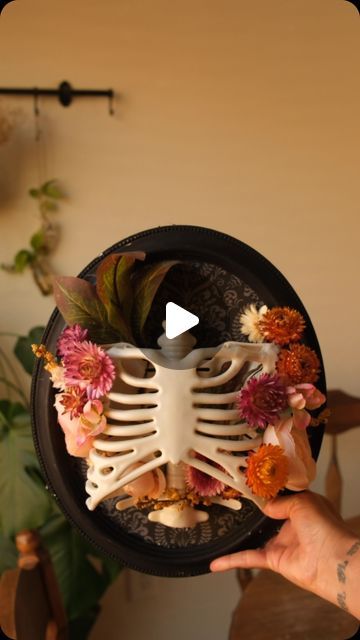 Sibia Torres Padilla | DIYs on Instagram: "How did I do?   I know it’s August but I have really been wanting to try this. I used a combination of fake and dried flowers for this.  I also used an oval frame and some twine to hold the rib cage in place. I wasn’t sure if hot glue would hold. this rib cage is from a 30 inch skeleton we had that the kids really loved, but it had two broken arms and was missing its head so I decided to use the rib cage for this DIY spooky decor." Diy Spooky Decor, Library Programming, Plastic Skeleton, Anatomy Physiology, Jack Skeleton, Broken Arm, Fall Stuff, Trick R Treat, Ikea Hackers