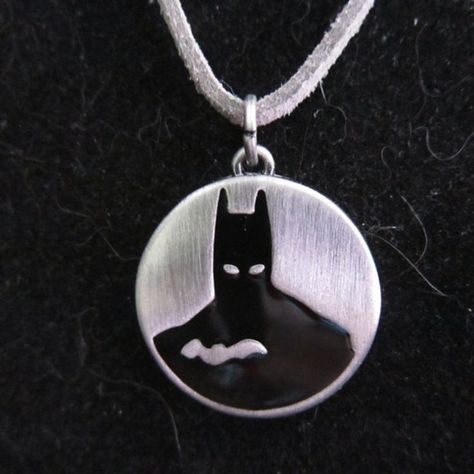 Show off your love for the caped crusader with this Batman pendant necklace. The pewter pendant features Batman's iconic silhouette on the front, while the back is engraved with the inspiring quote "Everything's impossible until somebody does it." The necklace strap is made of durable pleather and is finished with a silver-plated lobster claw clasp and a 3-inch adjustable chain for a customizable fit. With a maximum length of 20 inches, this necklace is perfect for any fan of the Dark Knight. Caped Crusader, Spartanburg Sc, Pewter Pendant, The Dark Knight, Crusades, Dark Knight, Silver Plate, Batman, Pendant Necklace