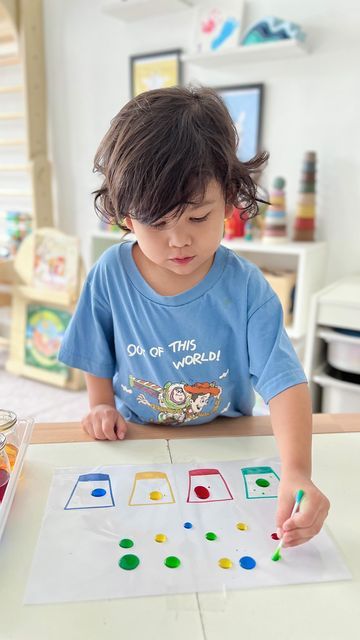 Peeja | Ayden & Alfie on Instagram: "Exercise fine motor skills with this colour sorting and mixing activity. It’s a great opportunity for preschoolers to learn about science too (how does the droplet moves on oily base). Materials: - A4 sheet protector - Oil (to wipe on the protector) - Pipette or eyedropper - Food dye and cotton buds ➡️ Cover the A4 paper drawing with the sheet protector. ➡️ Wipe some oil on the surface (to see the water droplet behaviour). ➡️ Use cotton buds to move the droplets. TIPS: Tape the protector sides on the table so it does not move. Our content is for educational purpose. ‼️ Strictly NO REPOST ‼️ #AydenAlfiePlays" Velcro Dot Activities, Eye Dropper Activities For Kids, Pipette Activities, Dropper Activities, Water Droplets Drawing, Colour Mixing Activities Preschool Science Experiments, Toddler Spray Bottle Activities, Awana Games, Moving Color