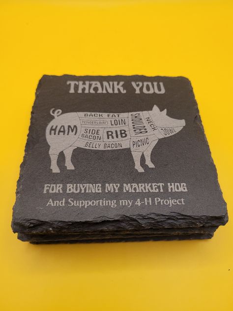 "This coaster set features a \"Thank you for Buying My Market Hog and Supporting My 4-H Project\" message. The natural texture and rich color of the slate add a rustic elegance to any setting, making them a great addition to your home, office. They have a rustic farmhouse charm that are perfect for entertaining but sturdy for daily use.  There are 4 slate coasters in the set that are 4 inches x 4 inches in size.  You can also customize it by changing the animal name (Hog to Pig, or Sow) or chang 4h Buyers Gift Ideas, Butcher's Cut, Showing Livestock, Farmhouse Charm, Slate Coasters, 4 H, Rustic Elegance, Natural Texture, Coaster Set