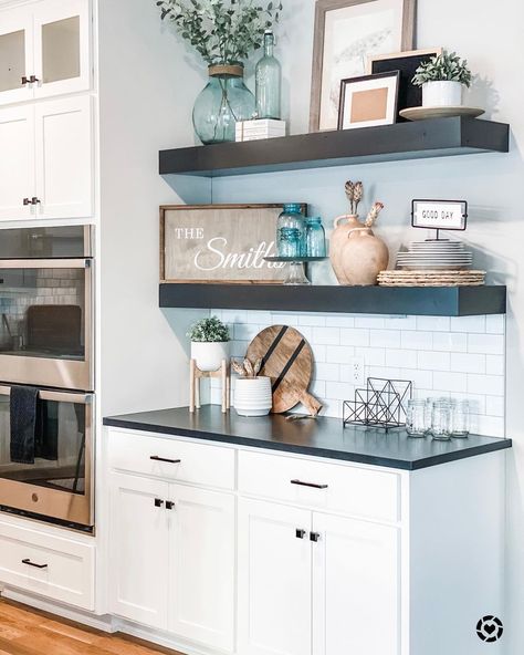 Cabinets With Floating Shelves Between, Kitchen With Black Shelves, Matte Black Floating Shelves Kitchen, Black And White Floating Shelves, Black Shelves In Kitchen, Floating Shelves Cabinet, Floating Shelves With Sconces Above, Staging Open Kitchen Shelves, White Kitchen Cabinets With Wood Shelves