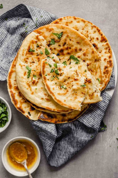 Soft and chewy homemade garlic naan bread! This is the EASIEST yeasted bread you will ever make. It’s addictively soft and full of flavor from garlic and browned butter. Learn how to make this skillet bread with a simple-to-follow recipe, step shots and cooking video. Naan Photography, Garlic Naan Bread, Garlic Naan Recipe, Pane Naan, Cheese Naan, Skillet Bread, Recipes With Naan Bread, Garlic Naan, Naan Recipe