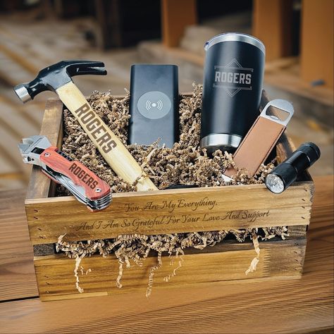 "Elevate your gifting game with our exclusive Blue Collar Man Set, a harmonious blend of practicality and sentimentality. This meticulously curated ensemble includes a personalized hammer, tumbler, and wrench tool, each engraved with a name of your choice. Whether it's tackling household repairs or enjoying a refreshing drink, these personalized tools add a distinctive touch to everyday moments. The set also features a portable phone charger, a sleek bottle opener, and a reliable flashlight, ensuring that your loved one is prepared for any adventure. All these treasures are presented in a rustic wooden crate, adorned with a sentimental message that turns the gift into a cherished keepsake. This toolbox gift set is more than just a collection of items; it's a thoughtful expression of care a Men Gift Baskets, Man Essentials, Practical Gifts For Men, Dorm Gifts, Gift Crates, Portable Phone Charger, Handy Man, Gift Baskets For Men, Wrench Tool