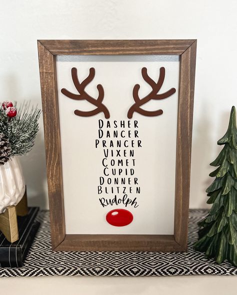 This 3D and laser engraved Reindeer name sign is the perfect addition to any Christmas decor. It is made to stand on its own so it styles well on entry tables, counter tops, shelves, mantles, etc. It has about 1/2 inch over hang that would allow it to hang on walls as well.  Materials: The frame is made from premium pine The Sign is made on a high quality MDF backer board with engraved lettering and laser cut acrylic antlers and nose The Sign pictured is 8x12 THE SIZE IS THE ENTIRE SIGN TOP TO BOTTOM INCLUDING THE FRAME *NO HANGING HARDWARE IS INCLUDED **PLEASE NOTE THAT EACH PIECE OF WOOD HAS DIFFERENT NATURAL CHARACTERISTICS SUCH AS CRACKS, KNOTS AND TEXTURE. THIS CAUSES SLIGHT VARIATIONS IN HOW THE STAIN ABSORBS. EACH FRAME IS UNIQUE. Reindeer Tree Theme, Rudolph Christmas Tree Theme, Reindeer Names Sign, Diy Christmas Wall Art Craft Ideas, Reindeer Porch Sign, Christmas Wall Collage Ideas, Reverse Canvas Christmas Signs, Funny Holiday Signs, Christmas Signs Funny