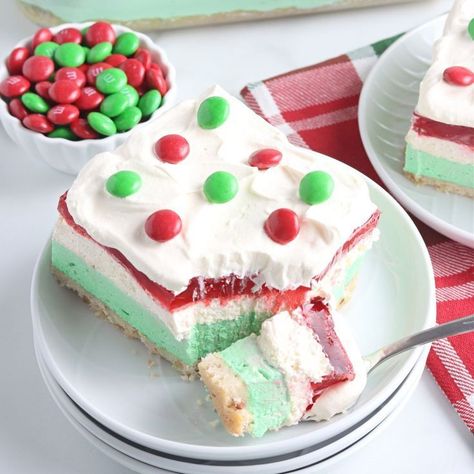 This easy no-bake Christmas lush is a delightful layered dessert perfect for this holiday season. A pecan shortbread style crust, topped with a lime cream cheese layer, and a strawberry layer that uses fresh strawberries come together to create this colorful Christmas dessert lasagna. Grab your ingredients and try this festive recipe today! Christmas Lush, Pistachio Recipes Desserts, Christmas Lasagna, Pan Desserts, No Bake Christmas, Festive Holiday Desserts, Pistachio Dessert, Jello Dessert Recipes, Layered Dessert