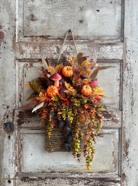 This fall door basket is filled with faux florals including fall colored eucalyptus and boxwood, acorns, faux mushrooms, mini pumpkins, and maple leaves. Finished with five acorn shaped jingle bells.Perfect for your door, entryway, hallway or any other space around your home. This fall wall basket is filled with Spanish Moss to keep things secure, so please keep out of rain. This basket has a thick jute twine hanger.  Only one available, ready to ship!  24 inches long, 12 inches wide, and 5 inches deep. measured leaf tip to leaf tip. Wreaths are made to order and may vary slightly. Wreaths can be used indoors and outdoors in a protected place, please keep out of rain and snow. Free Standard Shipping in the US. Message me if you have any questions or would like a custom order. Favorite my S Fall Wall Basket Decor, Fall Hanging Baskets, Thanksgiving Basket, Front Door Basket, Thanksgiving Baskets, Fall Entry, Front Door Baskets, Wreath Alternative, Door Basket