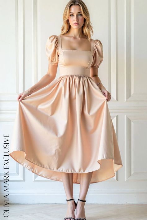 Crafted with a square neckline and puff sleeves that whisper of vintage charm, it cinches at the waist before cascading into a full, flowing skirt. The soft peach fabric drapes gracefully, promising movement with every step. A subtle high-low hemline adds a touch of modern sophistication, making this dress a timeless piece for any occasion. Dress With Puffed Sleeves, Peach Fabric, Peach Blush, Peach Dress, Flowing Skirt, Satin Midi Dress, Draped Fabric, Puffed Sleeves, Olivia Mark