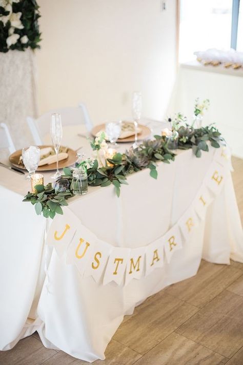 Simple Wedding Table For Bride And Groom, Sweetheart Table With Garland, Garland On Sweetheart Table, Simple Bride Groom Table, Bride And Groom Table Candles, Bride Groom Table Simple, Small Bride And Groom Table, Small Head Table Wedding, Sweetheart Table Garland With Flowers