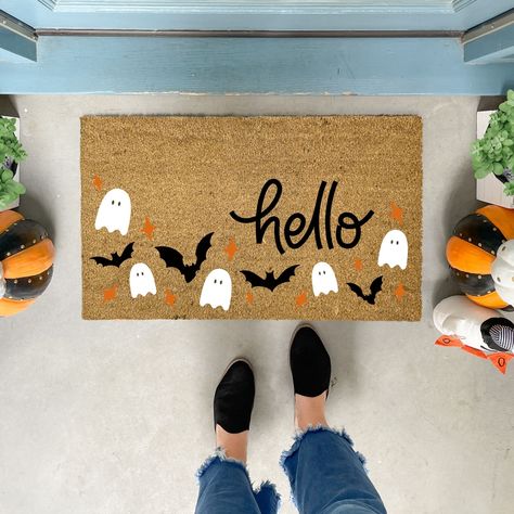 Welcome the spooky season with our charming handmade Halloween Doormat! This delightful doormat features a playful pattern of friendly ghosts, fluttering bats, and vibrant orange stars, all set against a backdrop that perfectly complements the bold "hello" text.  ✦Production time is 5-7 business days before shipping. Shipping is UPS Ground or USPS service. No PO Boxes, please. ✦All our coir welcome mats are natural brown in color. Minor variations are normal. ✦Each original design is available i Door Matts Ideas Halloween, Spooky Rugs Diy, Sip And Paint Halloween Door Mat, Door Mat Painting Diy Halloween, Door Mat Ideas Halloween, Halloween Door Mat Party, Painting Door Mats Diy Halloween, Pumpkin Door Mat, Halloween Outdoor Mat