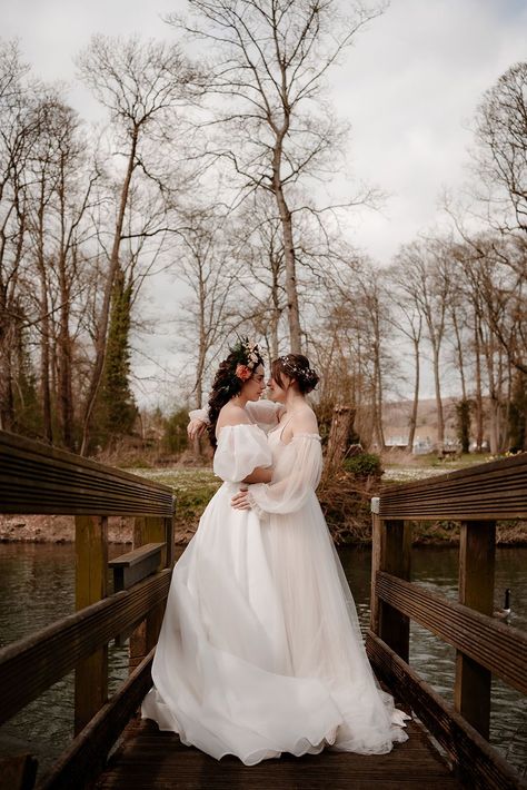 Two brides on the bridge at Mapledurham in ethereal wedding dresses with flower crown and hair vine bridal accessories Wedding Dresses Lesbian Couple, Lesbian Garden Wedding, Lesbian Wedding Dress, Two Bride Wedding, Lgbtq Wedding Two Brides, Two Brides Wedding, Sapphic Wedding, Lesbian Wedding Outfits, Wedding Contemporary