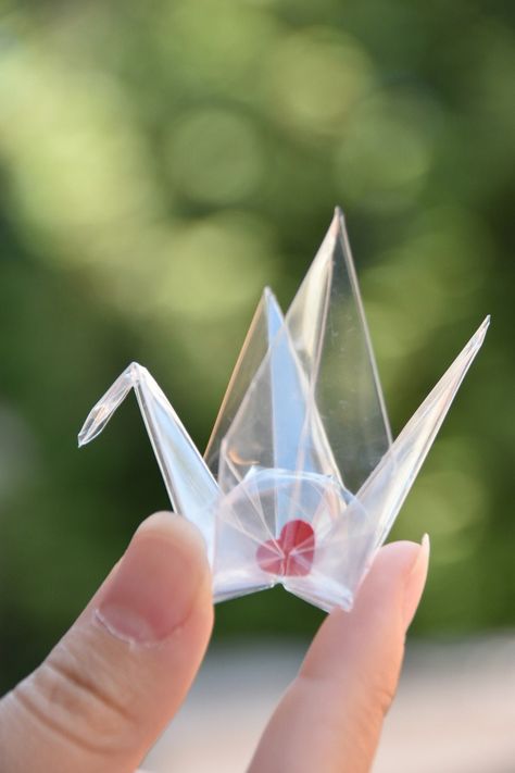 These transparent Orizuru cranes are made with 7cm x 7cm (Small), 10cm x 10cm (Medium) and 14cm x 14cm (Large)  transparency film, and each crane has a piece of heart shaped red paper in it This paper heart is not attached to the crane, so you can move it around This would be perfect for small gifts, party decor, wedding zxcake topper and lots more! Orizuru is a symbol of hope, peace and healing during illness or challenging times.  For more Origami Cranes options: https://www.etsy.com/ca/shop/O Peace Crane Origami, Paper Crane Decor, Origami Crane Decoration, Origami Hard, Flat Origami, Origami Installation, Kusudama Tutorial, Japan Decoration, Wedding Origami